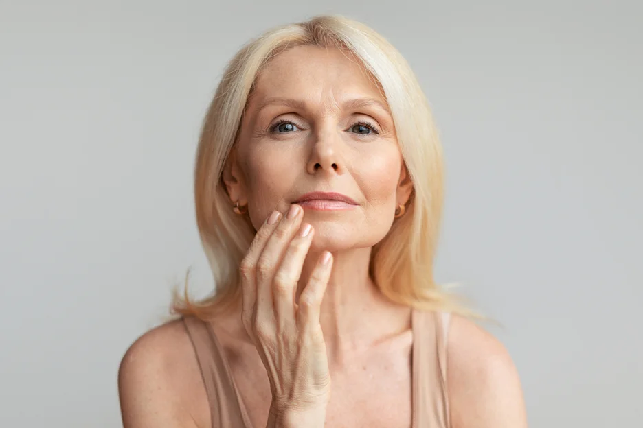 a woman touches her lips for side effects after lip filler procedure